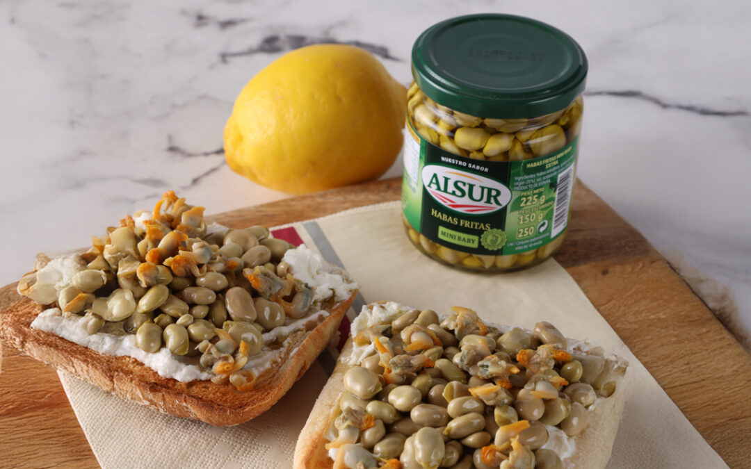 Tosta cremosa de habitas fritas, berberechos, ricota y limón